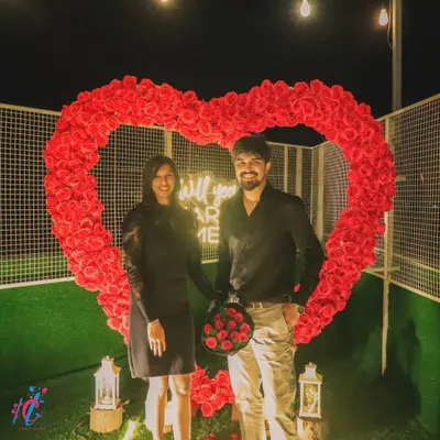 The perfect photo opportunity after a successful proposal. The happy couple stands inside the large, rose-covered heart, creating a beautiful memory of their special night.