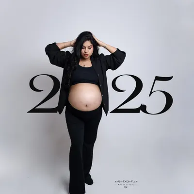 The "Boss Mom" look. This confident pose in a modern black pantsuit with the baby bump proudly displayed is for mothers who are leaders in every aspect of their lives.
