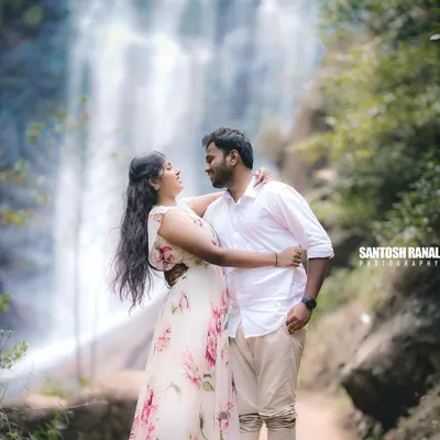A romantic couple's portrait set against a stunning waterfall backdrop. This kind of epic, natural scenery is perfect for creating memorable pre-wedding or engagement photos.