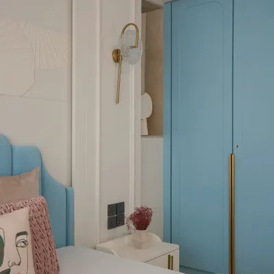 A serene sanctuary for a young couple, this master bedroom features a custom powder blue headboard and intricate 3D MDF panels. The design blends classic New English charm with modern luxury.