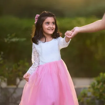 A charming portrait of a young girl in a beautiful pink dress, captured during an outdoor session. I focus on natural poses and expressions to let her personality shine.