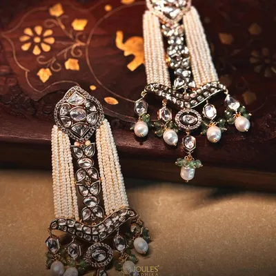 Bespoke craft designed to be remembered. These magnificent earrings feature cascades of pearls and intricate polki work, a true statement of bridal luxury.