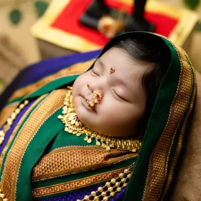 A beautiful 'Marathmoli' newborn shoot, celebrating Maharashtrian tradition. The rich texture of the Paithani saree wrap and the traditional jewelry make for a stunning cultural portrait.