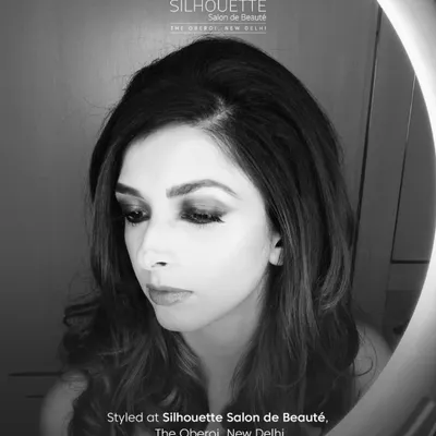 A black and white portrait of author Aishwarya Jha, styled by our team. The dramatic eye makeup and soft hair create a moody and artistic feel, captured beautifully under a ring light.