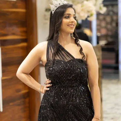 A perfect look for a glamorous evening event. The makeup features a soft smokey eye, luminous skin, and a neutral lip, allowing her sequined black dress and tiara to take center stage.