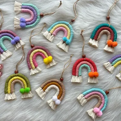 A cheerful collection of my mini macrame rainbow charms. These versatile pieces can be used as car dashboard ornaments, bag charms, or even small wall hangings. Each one is made with colorful cords and features a tiny pom-pom accent.