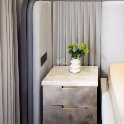 A detail of the Monarch Bed from a Suncity residence project. This shot shows the integrated bedside table with a marble top, set against the sculptural, upholstered panels of the extended headboard.