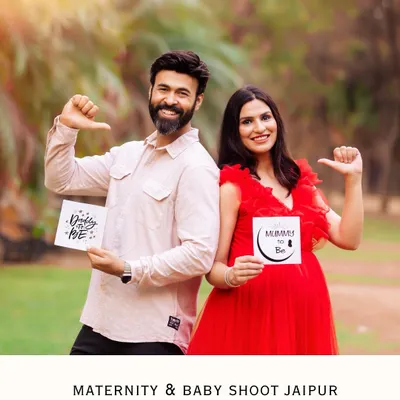 A fun and playful couple posing back-to-back with "Daddy to be" and "Mummy to be" signs. This is a perfect shot for a joyful pregnancy announcement.