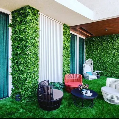 A complete balcony transformation featuring lush artificial grass flooring and vertical green walls. I can turn any outdoor area into a comfortable living space with custom seating arrangements.