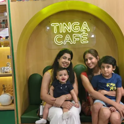A perfect spot for a break. Two moms relax with their young children in a cozy booth at our Tinga Cafe.