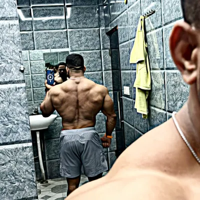A back-view mirror selfie showing the results of countless rows and pull-downs. A strong back is essential for a complete physique.