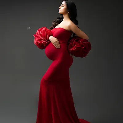 A portrait that is all about drama and elegance. This mamma looks absolutely stunning in our red Rosa gown, with its signature ruffled sleeves, against a classic dark studio backdrop.