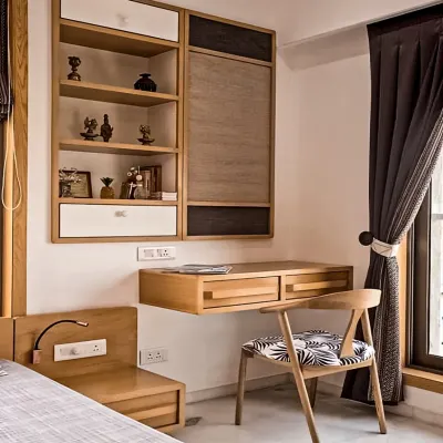 A sleek, wall-mounted study unit in a bedroom. The floating desk keeps the floor clear, while the combination of open shelves and closed cabinets provides versatile storage.