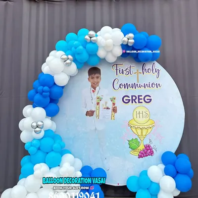 A beautiful decoration for a First Holy Communion. The round backdrop features a custom design and is framed by a blue and white balloon arch.