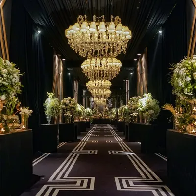 The entrance to this 25th-anniversary party was a grand hall of mirrors and memories. Massive chandeliers hung overhead as guests walked past a gallery of the couple's photos, creating a deeply personal and glamorous welcome.