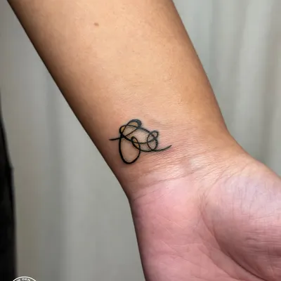The finished BTS symbol rework. By creating a single, solid, and flowing line, the tattoo now has a professional and polished look that truly represents the client's passion.