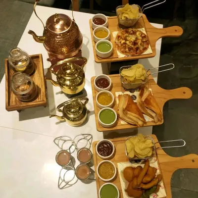Our high-tea catering is perfect for afternoon gatherings. We offer a variety of snack platters featuring items like mini pizzas, pakoras, and puff pastries, served alongside different types of chai and dips.