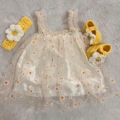 This daisy-themed set combines a delicate net frock with a soft satin lining for comfort. I've paired it with a handmade crochet headband and booties, both featuring a matching daisy flower.