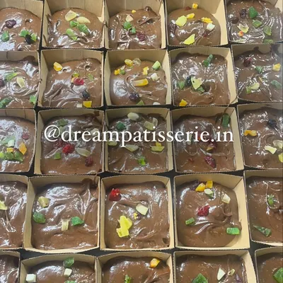 Preparing a large corporate order for Christmas. These are our rich plum cake batters topped with candied fruits before baking.