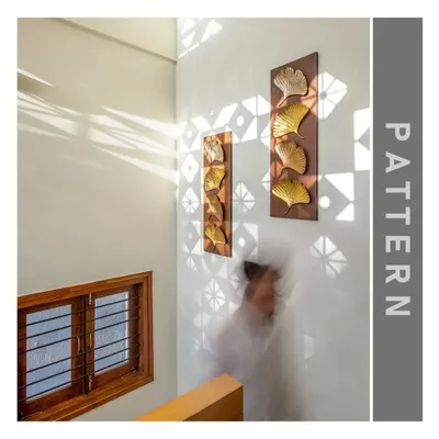 This image illustrates the principle of Pattern. The jali (screen) creates a beautiful, repeating pattern of light and shadow on the wall, transforming a simple staircase into a dynamic space.