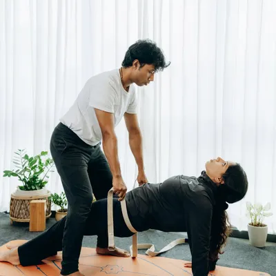 Here, I am using a yoga belt to help a student maintain hip elevation and stability in Purvottanasana (Upward Plank Pose). This adjustment ensures the lift comes from the legs and core, not from straining the lower back.