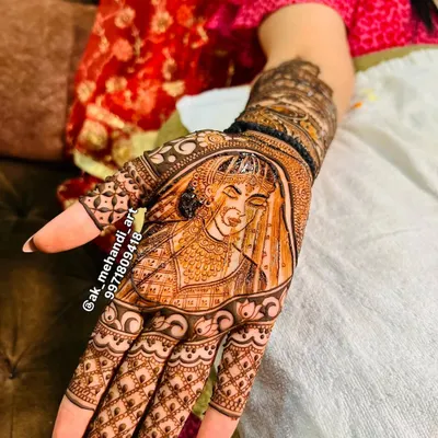 A beautiful portrait of a bride in her wedding attire, intricately detailed in henna on the palm. This is a wonderful way to personalize your bridal mehndi.