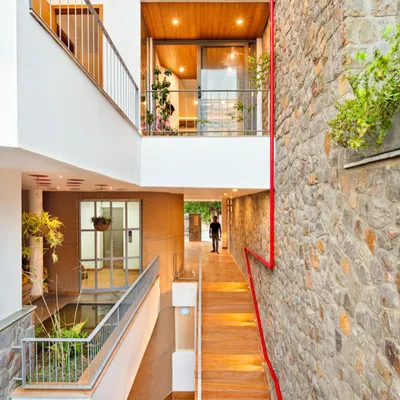 A complete view of the People Tree House, showing the interplay between the built environment and natural elements like the central water feature and extensive plantings.
