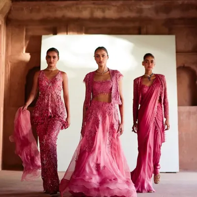 A full-length shot from a campaign showcasing three coordinated bridesmaid looks in shades of pink. The styling focuses on creating a harmonious group visual while allowing each outfit's unique details to shine.