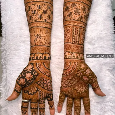 Happiness is handmade with henna. This full-arm bridal design combines traditional elements like elephants and lotuses with intricate geometric patterns for a stunning look.