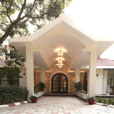 The entrance of the Doon Homestay was designed to be a grand yet intimate welcome. The vaulted ceiling of the portico, illuminated by elegant chandeliers, offers a preview of the comfort and classic design found within the home.