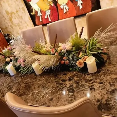 This modern centerpiece is perfect for a stylish dinner party. I used a mix of pampas grass, fresh flowers, and greenery, with several white pillar candles placed throughout the arrangement to create a warm and inviting look on the dining table.