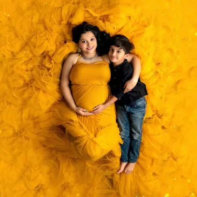 The journey to motherhood is a universe of its own. This stunning overhead shot celebrates the beauty and power of a mother-to-be, wrapped in a vibrant gown that's as full of life as she is.