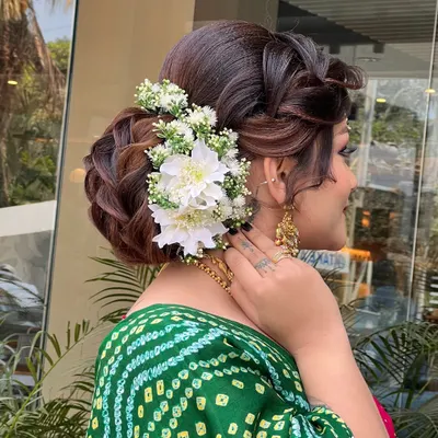 This is one of my favorite bridal updos, perfect for a wedding ceremony. I created this intricate braided bun and adorned it with fresh white flowers to match the bride's beautiful green bandhani saree.