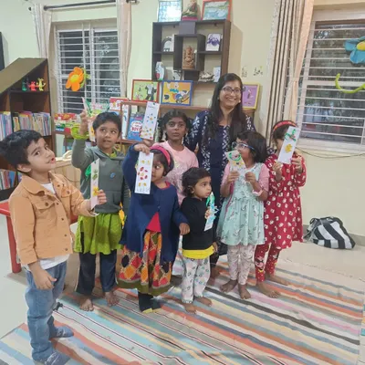 A proud moment. The storyteller poses with the children as they all hold up the beautiful bookmarks they created together.