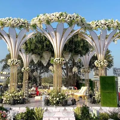 An architectural masterpiece, this grand white mandap features stylized floral pillars and a canopy of fresh white blooms, creating a modern yet timeless look for an outdoor wedding.