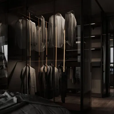 This view shows how a glass wardrobe can integrate seamlessly into a bedroom. The transparent doors and internal lighting make the clothing collection part of the room's decor, creating a sense of openness.