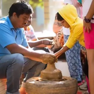 I bring a real pottery wheel to your party for a unique, hands-on activity. Here you can see me guiding a child as she creates her own pot. It's a wonderfully messy and creative experience that kids remember long after the party is over.