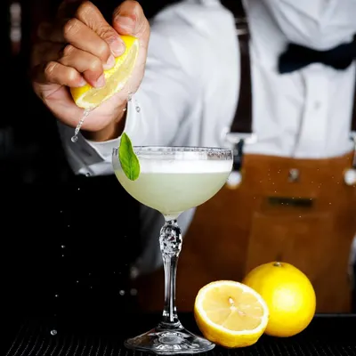 Capturing the action of a lemon being squeezed into a cocktail, this shot is all about freshness and craft.