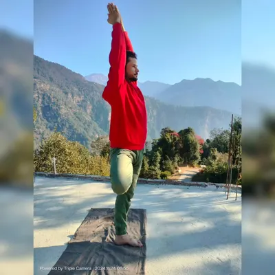 A side view of Vrikshasana, or Tree Pose, against a mountain backdrop. This posture is a beautiful expression of balance and grounding, which are key themes in my Hatha yoga sessions.