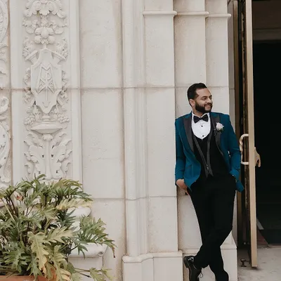 For the groom who wants to stand out, we styled this unconventional yet elegant teal tuxedo by Sarab Khanijou. It was the perfect, bold choice to complement his bride's ivory lehenga for their Catholic wedding.