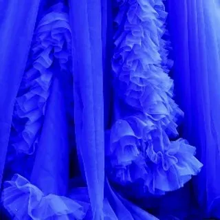 A close-up of the cascading ruffles on one of my royal blue gowns. This texture adds depth and dimension, making the dress visually stunning from every angle.