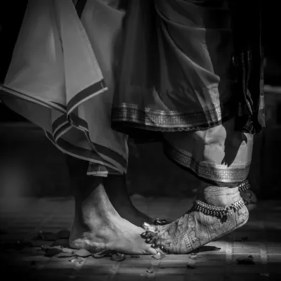 A symbolic black and white shot of the couple's feet during a ritual, representing their first steps together on a shared path.
