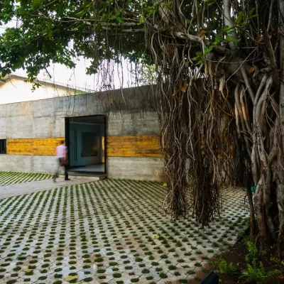 The entrance to the retrofitted ATE complex in Pune. I preserved the old banyan tree and used grass pavers and board-formed concrete to create a new entrance that respects the site's history while signaling its new purpose.