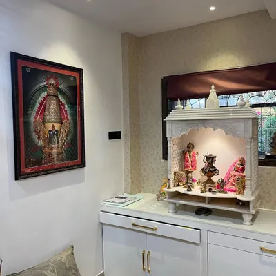 A beautiful home mandir I designed and installed. This piece combines a classic white marble temple with modern, high-gloss white cabinetry for storage, complete with elegant gold handles and dedicated overhead lighting to create a peaceful, sacred space.