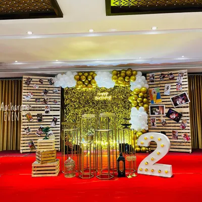 For this second birthday, we combined a glam gold sequin backdrop with rustic wooden pallets. This allowed us to create a beautiful milestone photo board, displaying the family's favorite pictures right on the main stage.