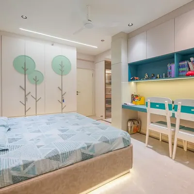 This child's bedroom is designed for both study and play. The built-in desk with dual seating is perfect for homework, while the whimsical tree motif on the wardrobe doors adds a touch of fun. Ample storage keeps the space organized and clutter-free.