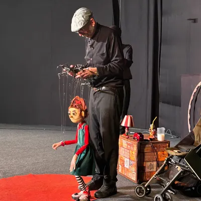 A beautifully detailed marionette of a young girl from the Italian show 'Pay Attention to Those Two'. The puppeteer's skill is evident in the subtle, lifelike posture of the character.