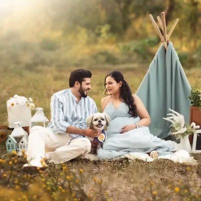 The whole family is excited, including the furry members! This outdoor picnic scene with their beloved dog is a perfect example of a fun, relaxed, and inclusive maternity session.