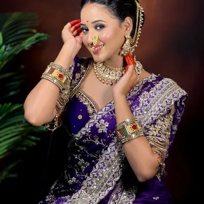 A flawless Maharashtrian bride. This look features a classic updo, a beautiful Paithani saree, and makeup that highlights her features, including the traditional nath and bindi.