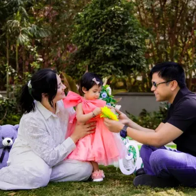 A candid family moment during an outdoor photoshoot in Bangalore. Surrounded by greenery, we capture genuine interactions as parents play with their little one, creating natural and heartfelt memories.